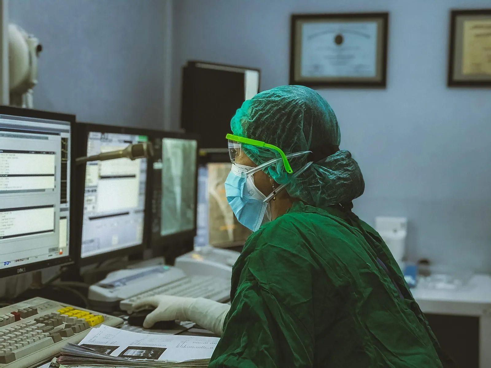 Healthcare clinician working at a multi-screen workstation